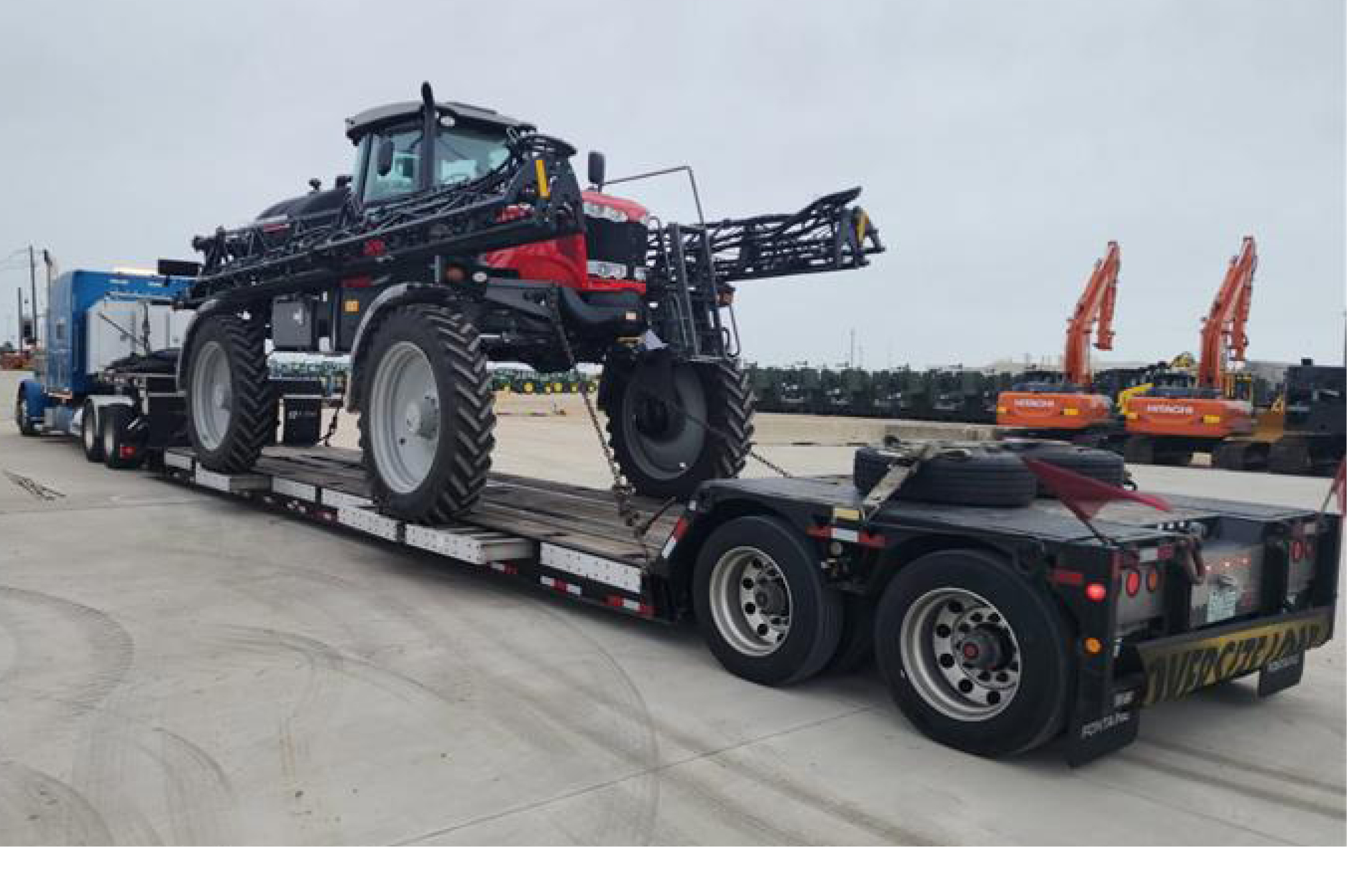 Buchanan Logistics hauling agricultural equipment with a double-drop flatbed trailer