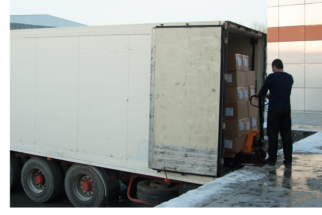 Semi truck trailer being loaded with freight by a worker