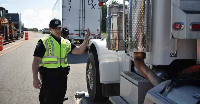 officer waves semi forward