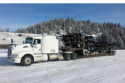 Buchanan step deck flatbed transporting a delivery load of automotive parts to Canada.