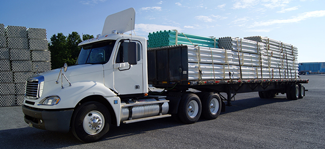 Buchanan Logistics Day Cab delivering a load of freight on a flatbed trailer via a Buchanan truck driver.