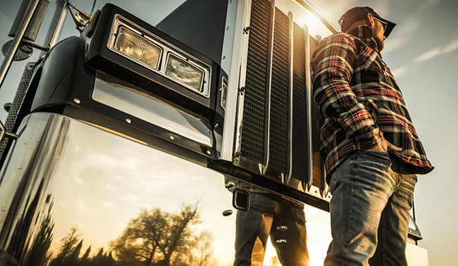 A truck driver with his semi waits for his next load because of deadheading. A truck driver with his semi waits for his next load because of deadheading.