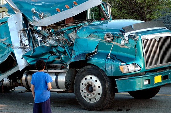 Boy looking at truck with damage